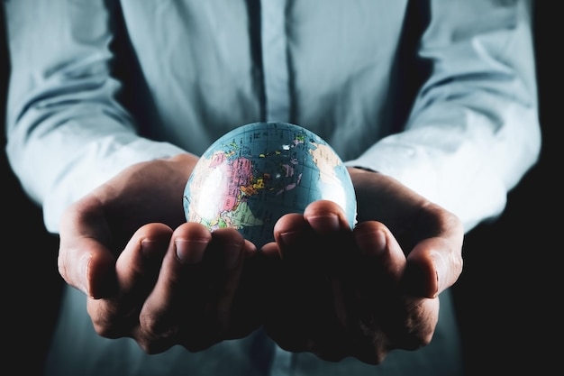 Businessman holds a small globe in his hand