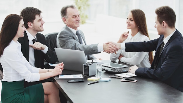 Businessman and investor shake hands at the negotiating table