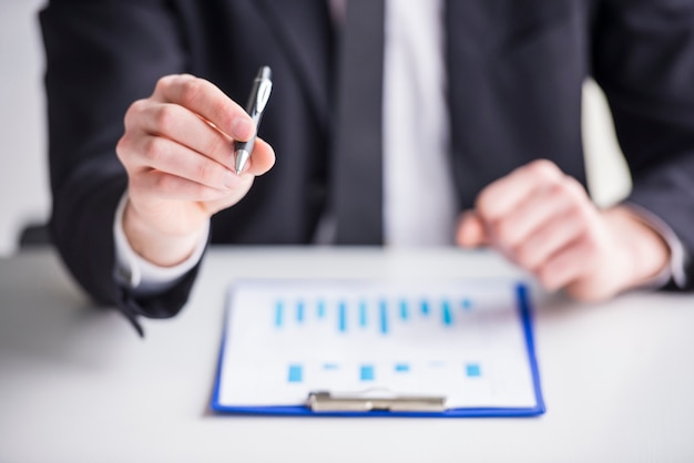 Businessman is analyzing graphs in his office.