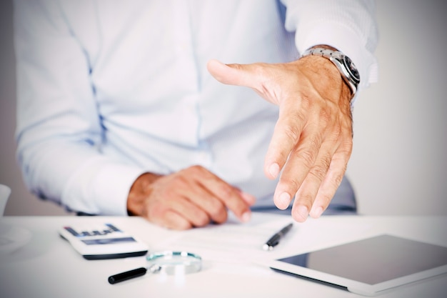 A businessman is extending his hand for a handshake