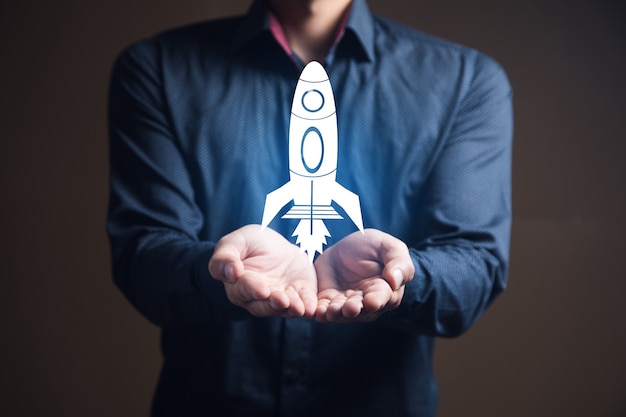 Businessman is holding a rocket. startup concept