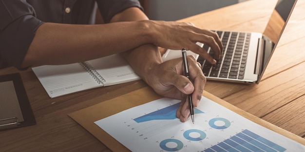 Businessman is reading a monthly sales graph in his office Sales management concept