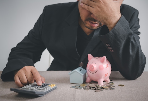 Businessman is stressed out of losing their jobs and insufficient savings to pay for a mortgage. focus on  calculator and Impacts of the epidemic of COVID 19