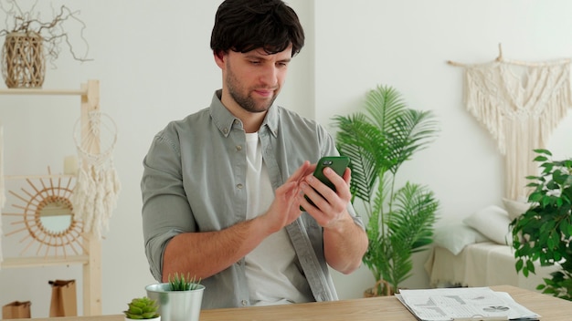 Businessman is using a smartphone and smiling while working in office