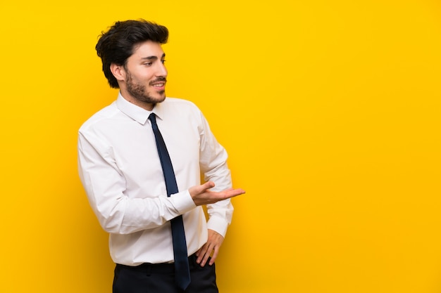 Businessman on isolated yellow  extending hands to the side for inviting to come