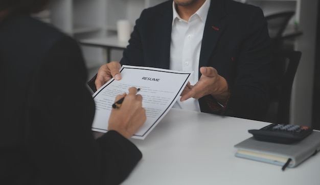 Businessman or job seeker review his resume on his desk before send to finding a new job with pen necktie glasses and digital tablet