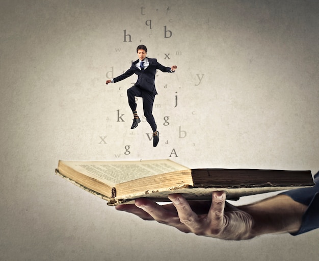 Businessman jumping out of a book