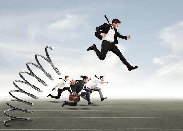 Businessman jumping on a spring during a race with opponents