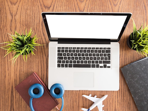 Businessman laptop traveler image  from top vie, books , headphones  , pot of grass