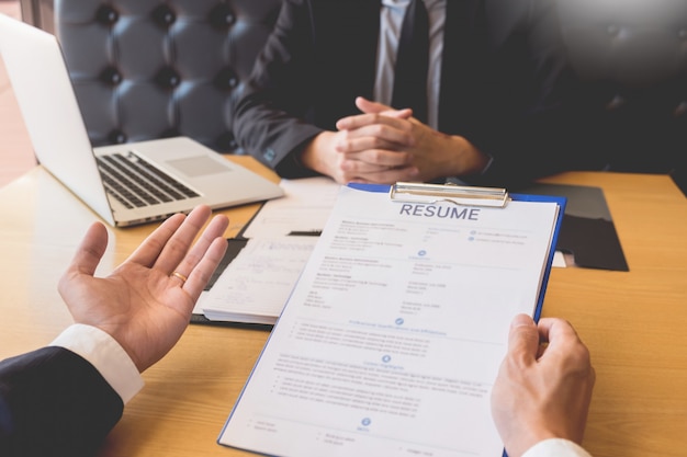 Photo businessman listen to young attractive man explaining about his profile candidate interview answers