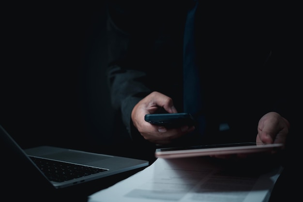 businessman looking at report on mobile and analyzing data with technology in business investment