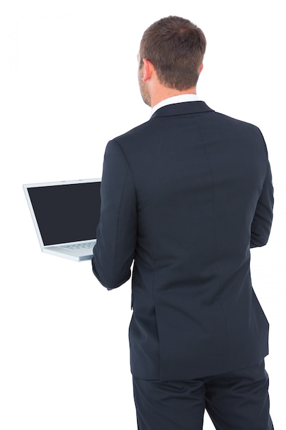 Businessman looking up holding laptop