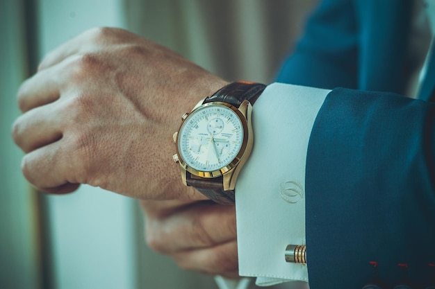 Businessman looks at the clock on his hand looks at the timepunctuality