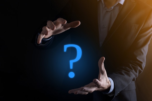 Businessman man hand hold interface question marks sign web. Ask quiestion online, FAQ concept, what where when how and why, search information on internet.