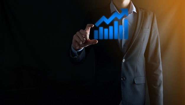 Businessman man holding a graph with positive profits growth