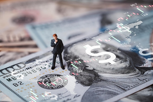 Businessman miniature figure standing on USD banknote with stock market chart graph for currency exchange of global trade forex and Fed increase interest rate to stop inflation concept