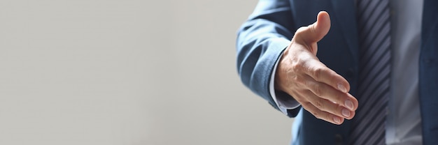 Businessman offer hand to shake as hello in office closeup