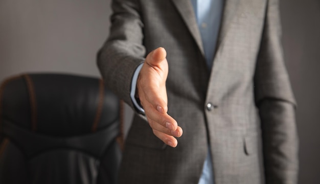 Photo businessman offering hand for handshake at office