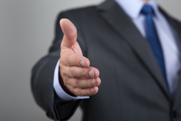 Businessman offering his hand for handshake. Greeting or congradulating gesture. Business meeting and success