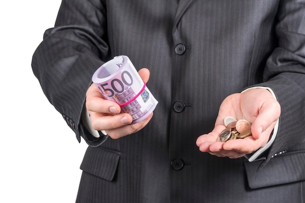 businessman offers money - in one hand a tube of paper euro and in the other a few euro cents, isolated on a white background