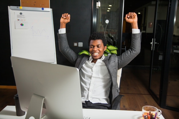 Businessman at office, success gesture, goal reached, happy man