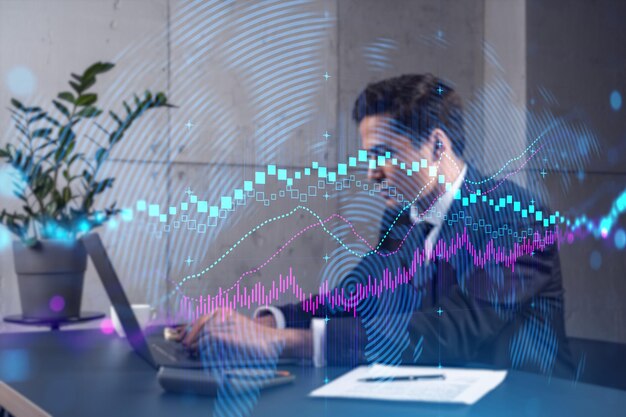 Businessman in office working with laptop technology forex online trading graph and chart typing computer assemble data drawing concept Double exposure