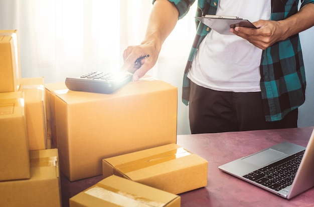 businessman packing product in cardboard box deliver to customer working at home office