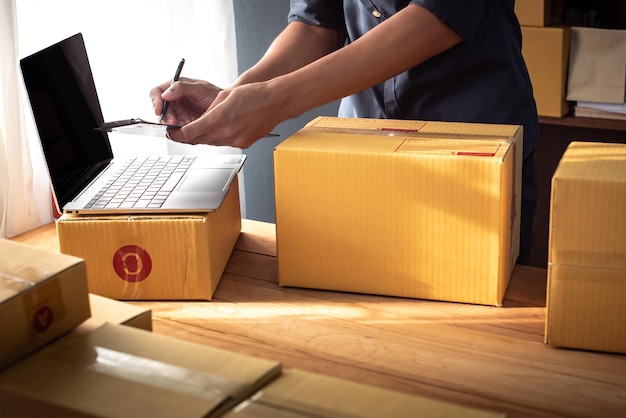 businessman packing product in cardboard box deliver to customer working at home office