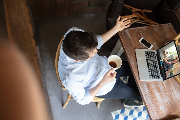 Businessman participate video conference looking at laptop screen during virtual meeting, videocall webcam app for business, close up. Remote working, freelance, education, lifestyle concept.