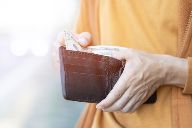 Businessman Person holding an wallet in the hands of an man take money out of pocket.