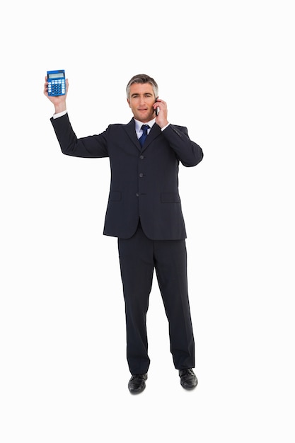 Businessman on the phone showing a calculator 