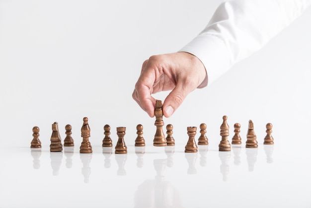 Businessman playing chess moving dark king piece