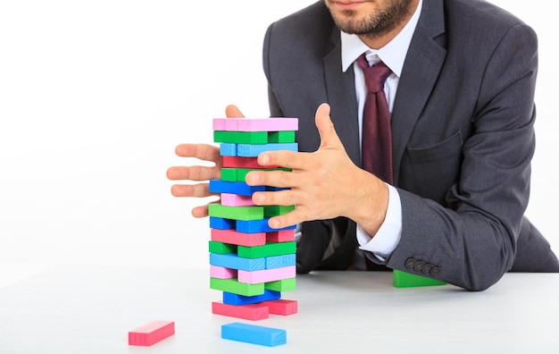 Businessman playing wooden blocks game