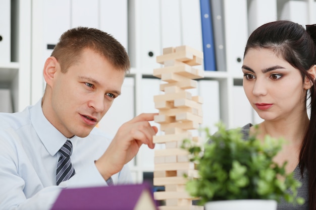 Photo businessman plays in a strategy of jenga hand