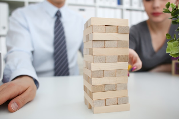 Businessman plays in a strategy of jenga hand