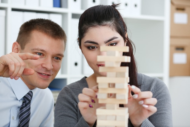 Businessman plays in a strategy of jenga hand