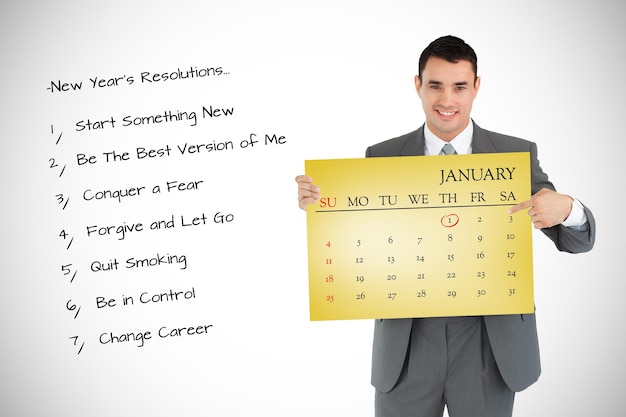 Photo businessman pointing at calendar he is holding against yellow card