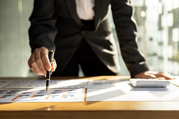 Businessman points to financial documents he owns a startup company he sits checking the companys financial summary prepared by the finance department Management concept of startup company