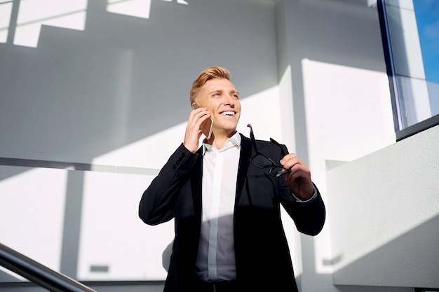 Businessman positive blonde in a business suit with glasses