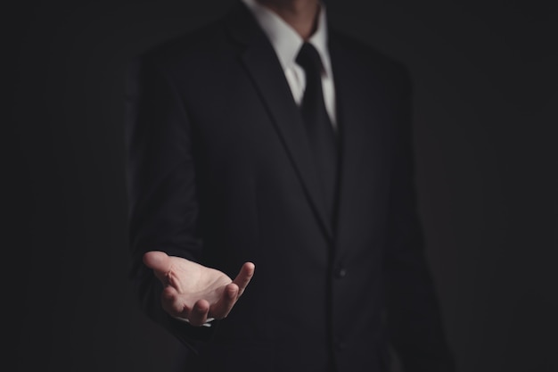 businessman presenting in black suit on black