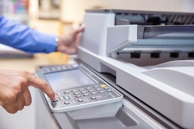 Businessman press button on the panel of photocopier.