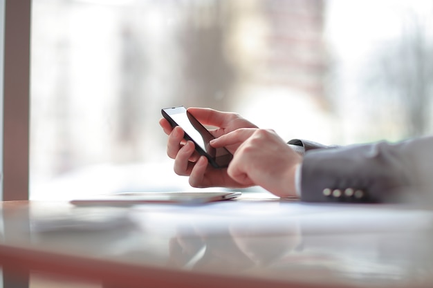 businessman presses his finger on the screen of the smartphone.