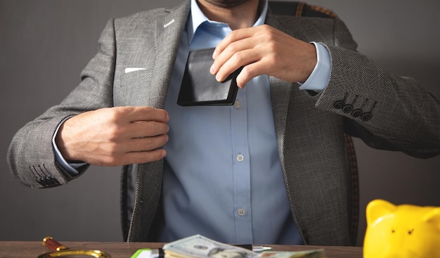 Businessman pulls his leather wallet into suit pocket