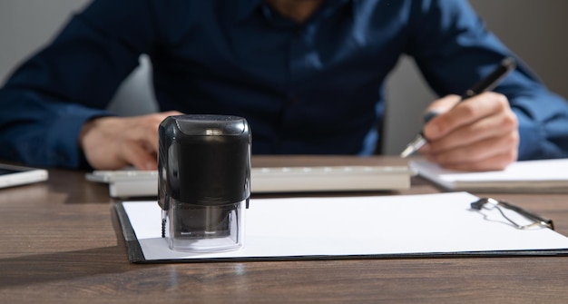 Businessman puts a stamp on the documents in the office