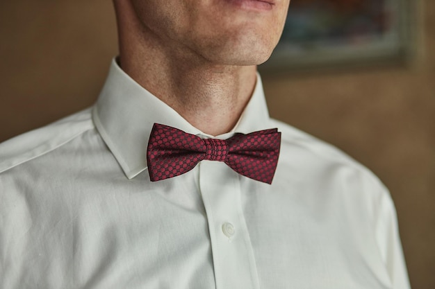 Businessman putting on bow tie man butterfly clothesgroom getting ready in the morning before wedding ceremony