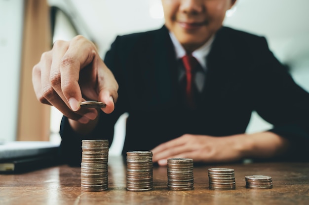 Businessman putting coin stack step up increase save money 