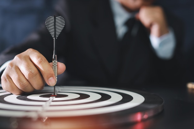 Businessman putting dart in the center of the target