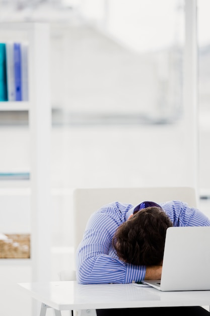 Businessman putting his head down on desk