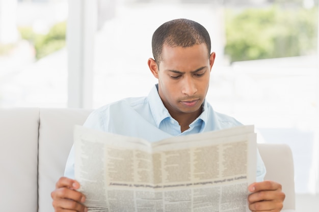 Businessman reading newspaper on the couch