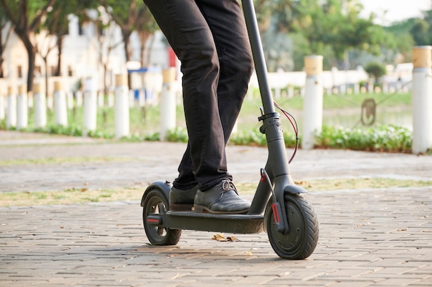 Photo businessman riding on cooter in park